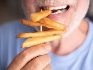 senior with a the constant hunger feeling snacking on junk food